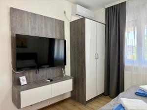 a bedroom with a flat screen tv on a wall at Royal Apartmani 3 in Paraćin