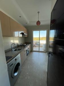 a kitchen with a washing machine and a sink at Les perles de tamaris dar bouazza in Dar Mohammed Ould Haj Jilali