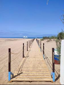 a wooden boardwalk leading to the beach at Les perles de tamaris dar bouazza in Dar Mohammed Ould Haj Jilali