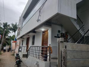 a building with a motorcycle parked outside of it at PR Home Stay in Tiruvidaimarudūr
