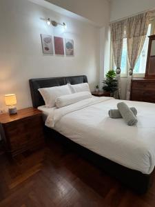 a bedroom with a large white bed with two pillows at Roamia Retreat - Tropical house in Kuah