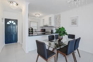 Una cocina y un comedor con mesa y sillas. en Modern Coastal Condo in Big Bay, en Cape Town