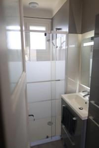 a white bathroom with a shower and a sink at Douce escale - Climatisation in Marzy +35 photos