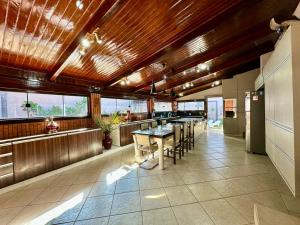 a large kitchen with a table and some windows at Pousada Paraiso in Paracatu