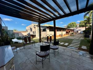 a patio with a table and chairs under a pergola at Pousada Paraiso in Paracatu