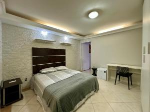 a bedroom with a large bed and a chair at Pousada Paraiso in Paracatu +20 photos