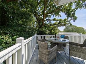 a patio with a table and chairs on a deck at St Helens Beach Retreat in Saint Helens