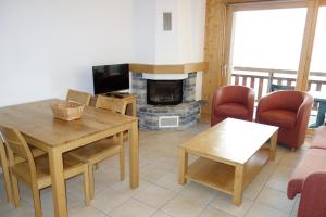 a living room with a table and a fireplace at Plein Ciel VA 032 - MOUNTAIN apartment 6 pers in Veysonnaz