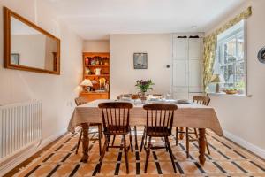 een eetkamer met een houten tafel en stoelen bij Stone Cottage - Swanage in Swanage