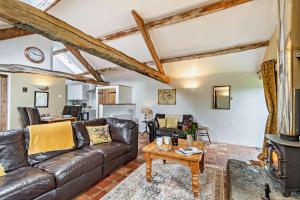 a living room with a leather couch and a table at Topshill in Kirk Ireton