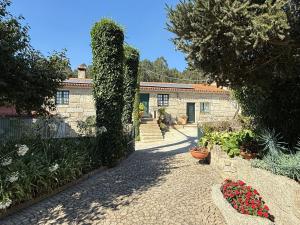 a garden with plants and flowers in front of a building at Casa de Agrelos Country House in Penafiel