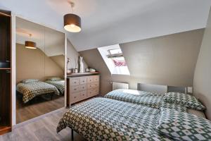 a bedroom with two beds and a mirror at Le Boucard - Terrasse - Proche plage in Saint-Nazaire