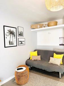 a living room with a couch and yellow pillows at BEACH WALK Climatisé piscineparkingproche mer in Bandol