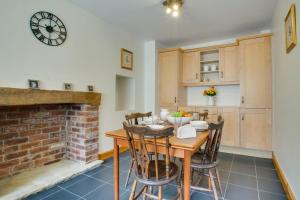 a kitchen and dining room with a table and a fireplace at Jaret House in Tideswell