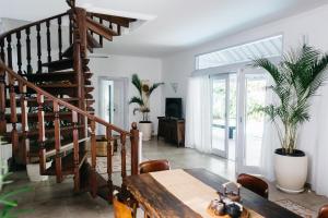 a living room with a wooden table and stairs at 3BR, Sanur, Villa, Warm Pool, Piano, King, Tubs in Denpasar