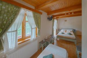 a bedroom with a bed and a large window at Pensiunea Vanatorul in Băile Tuşnad +63 photos