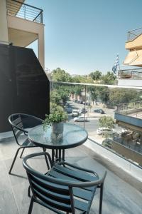 ein Tisch und Stühle auf einem Balkon mit Aussicht in der Unterkunft TOWER 15 Suites, Nilie Hospitality MGMT in Thessaloniki