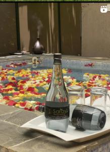 ナイロビにあるSarayu Wellness Instituteのカメラと一緒に皿の上に置かれたソーダのボトル
