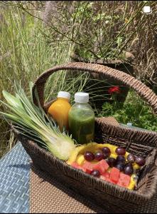 ナイロビにあるSarayu Wellness Instituteのテーブルの上に果物とジュースが入ったバスケット