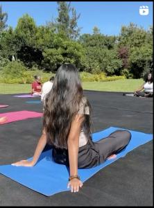 ナイロビにあるSarayu Wellness Instituteの公園でヨガマットの上に座っている女性