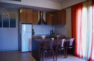 a kitchen with a table and chairs and a refrigerator at Tsokas Hotel in Finikounta