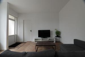 a living room with a couch and a flat screen tv at Modern apartment nearby Eindhoven in Leende
