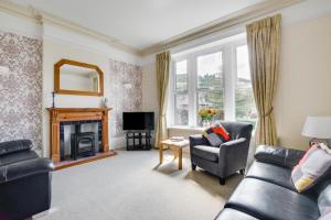 un salon avec un canapé et une cheminée dans l'établissement Araglen, à Matlock