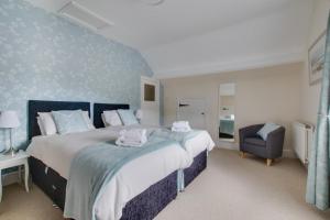 une chambre avec un grand lit et une chaise dans l'établissement Araglen, à Matlock