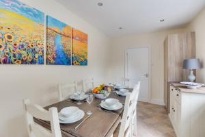 une salle à manger avec une table et un tableau au mur dans l'établissement Araglen, à Matlock