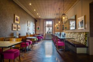a restaurant with pink chairs and tables and a bar at The Tontine Hotel in Peebles