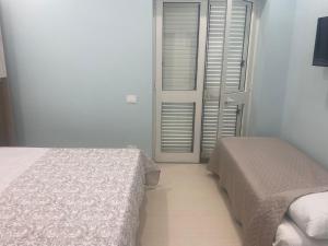 a bedroom with two beds and a window with shutters at Falegnameria del Conte in Montecorice