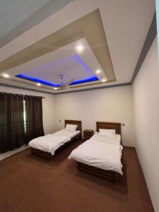 锡卡都Aba-SHAH GUEST HOUSE SKARDU的蓝色天花板的客房内的两张床