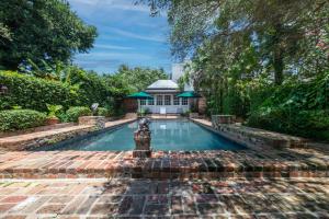 a swimming pool in a backyard with a gazebo at Audubon Cottages in New Orleans