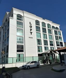 Un coche blanco aparcado delante de un edificio en Loft Refugio Azul - 307, en Arraial do Cabo