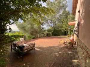 a patio with a couch and chairs on a brick yard at La casa nel bosco in Lari