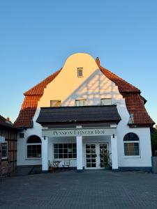 a white building with a brown roof at Pension Üfinger Hof in Salzgitter