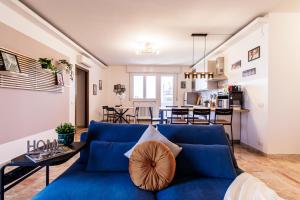 Una sala de estar con un sofá azul y una mesa. en Skyline Ottavo Cielo, en Módena