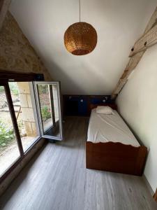 a bedroom with a bed and a large window at Cottage en nature Le Pigeonnier de la Manse in Saint-Épain +8 photos