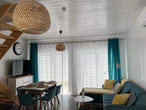 Una sala de estar con un sofá azul y una mesa. en Turkusowy Domek, en Władysławowo
