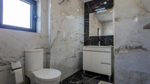a white bathroom with a toilet and a sink at Cantinho do Azibo 