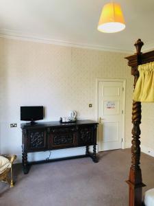 a living room with a table and a television at Albany, Brighton & Hove in Brighton & Hove