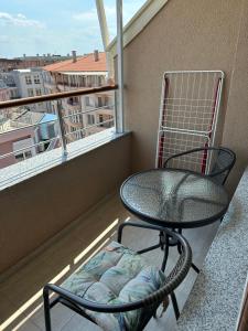 a black chair sitting on a balcony with a window at Apartment Tuthon in Pomorie