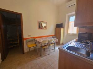 a kitchen with a table with chairs and a sink at Appartamento Soliluna - Goelba in Cavo