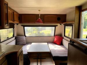 a small kitchen with a table in the back of a caravan at Ubytování v divočině in Huntířov