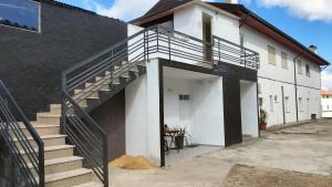 un edificio bianco con una scala accanto a un garage di Casa T2- Entre Porto e Aveiro a Carregosa