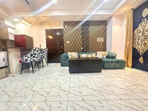 a lobby with a couch and a table and a kitchen at Two Bed Luxury Apartment in Islamabad