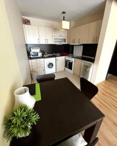 a kitchen with a black table and a dining room at Sirena Appartment in Sveti Vlas +10 photos