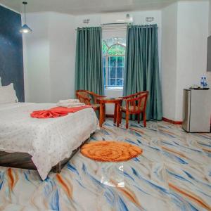 a bedroom with a bed and a table and chairs at Twalumba Lodge in Lusaka