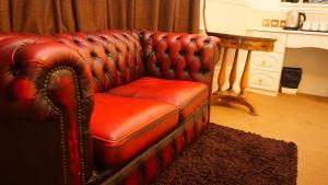 a red leather couch sitting in a living room at Albany, Brighton & Hove in Brighton & Hove