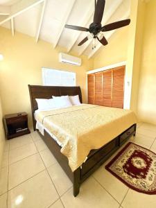 a bedroom with a bed with a ceiling fan at Santa Maria's View in Crosbies +22 photos